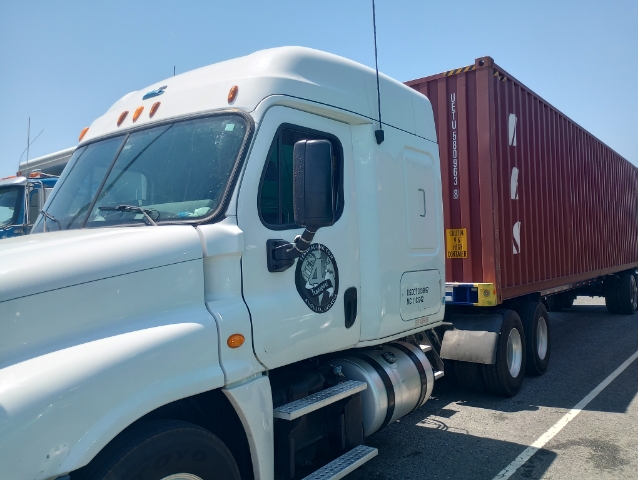 A white color truck with a red container